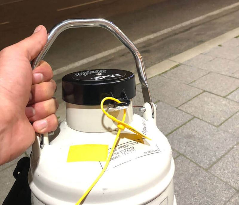 Cryopath courier carrying a sealed cryogenic dry shipper by hand